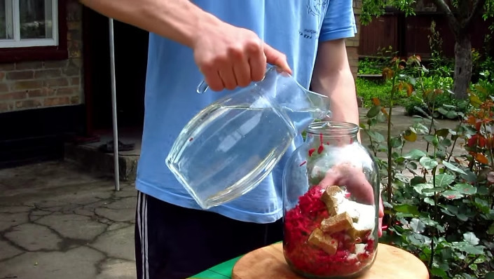 1. Этап. Квас из красной свеклы: Переложите свеклу в банку, добавьте к ней хлебные сухарики, всыпьте сахар и залейте все чистой питьевой водой.