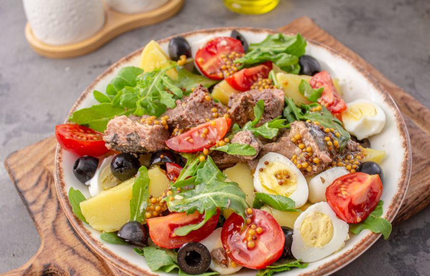 1. Этап. Салат Нисуаз с рукколой: Добавьте нарезанные на половинки помидоры черри и полейте салат оставшимся соусом.