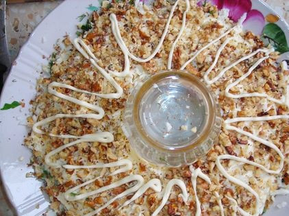 1. Этап. Салат Браслет: 7. Грецкие орехи измельчить с помощью блендера или кухонного молоточка. Выложить в салат и немного промазать майонезом.