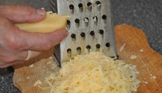 1. Этап. Куриное филе с грибами в духовке: Потрите сыр на крупной терке. Переложите его в тарелку и оставьте в покое на некоторое время.