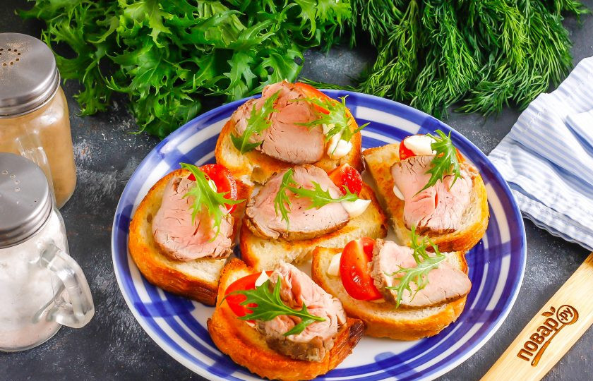 1. Этап. Канапе с ростбифом: Промойте листья рукколы и украсьте ими приготовленные канапе.