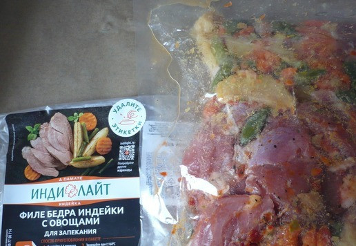 1. Этап. Филе бедра индейки с овощами запеченное: Затем действуем по инструкции. Запекать блюдо будем в вакуумной упаковке (в которой находится филе бедра индейки с овощами). Необходимо удалить этикетки с обеих сторон упаковки. Сделать это легко, есть специальные уголки. Затем сделайте 3-4 прокола в верхней части упаковки. Поместите продукт на холодный противень, застеленный бумагой для запекания. Запекайте при температуре 160 градусов 60 минут.