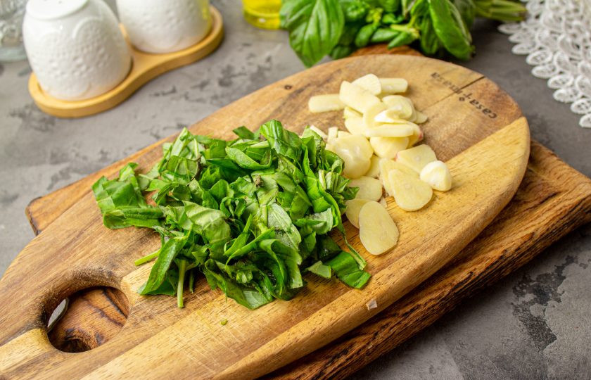 1. Этап. Перец с базиликом на зиму: Пока печется перец, базилик промойте и обсушите, нарежьте на тонкие полоски. Чеснок очистите и нарежьте на тонкие пластины. Количество базилика и чеснока зависит от ваших предпочтений.