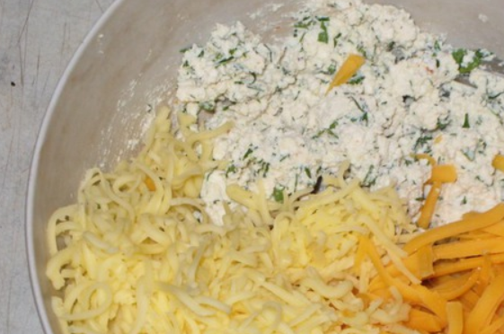 1. Этап. Пирог с колбасой и сыром: Добавляем тертый сыр (больше половины), перемешиваем.