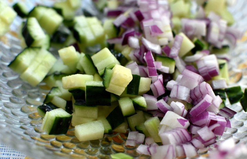 1. Этап. Салат из овощей-гриль со свежим огурцом: Нарежьте огурец и лук мелкими кубиками. Выложите в миску. У кинзы оборвите и крупно нарубите листья. Можно заменить кинзу петрушкой, но вкус станет проще.