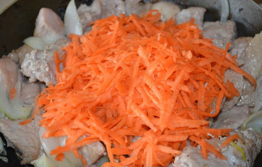 1. Этап. Подлива мясная: Морковь очистите и вымойте. Натрите ее на крупной терке и выложите к мясу и луку в сковородку. Обжаривайте ингредиенты еще минут пять, постоянно помешивая.