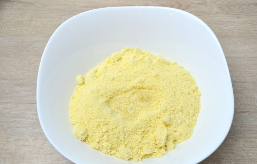 1. Этап. Американский лимонный пирог: Пересыпьте мучную крошку в миску, сделайте углубление, влейте в него 2 ст. ложки холодной, лучше ледяной воды.