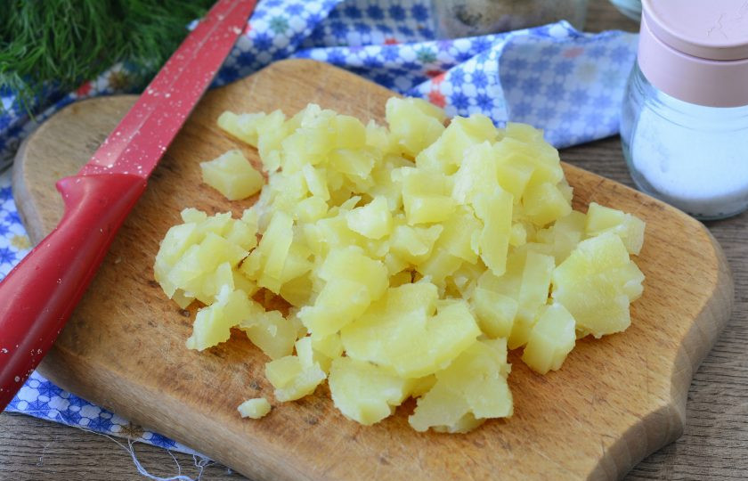 1. Этап. Салат с бужениной и кукурузой: Картофель сварите, остудите, почистите и нарежьте кубиками.