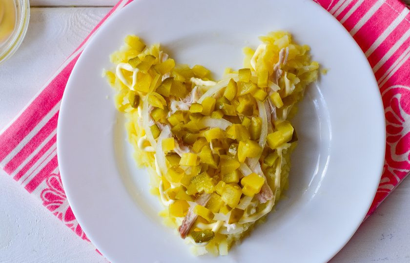 1. Этап. Новогодний салат Крысенок: Огурцы нарежьте кубиками и выложите поверх салата.