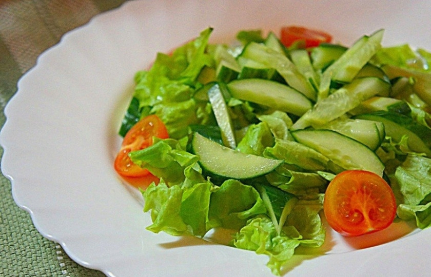 1. Этап. Салат пикантный с креветками: Вымойте листья салата, аккуратно уложите их на дно тарелки. Возьмите черри и огурчик. Вымойте их. Порежьте огурец половинками кружочков. Черри порежьте пополам. Посолите сверху, немного поперчите.