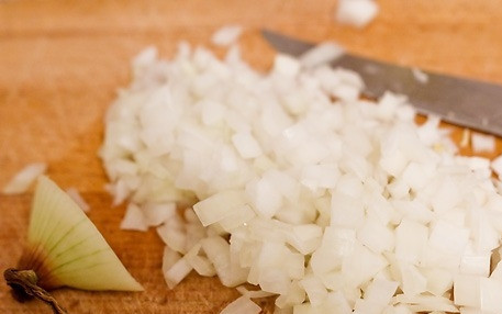 1. Этап. Курица по-милански: Репчатый лук чистим и обжариваем на сковороде с добавлением масла до золотистого цвета.