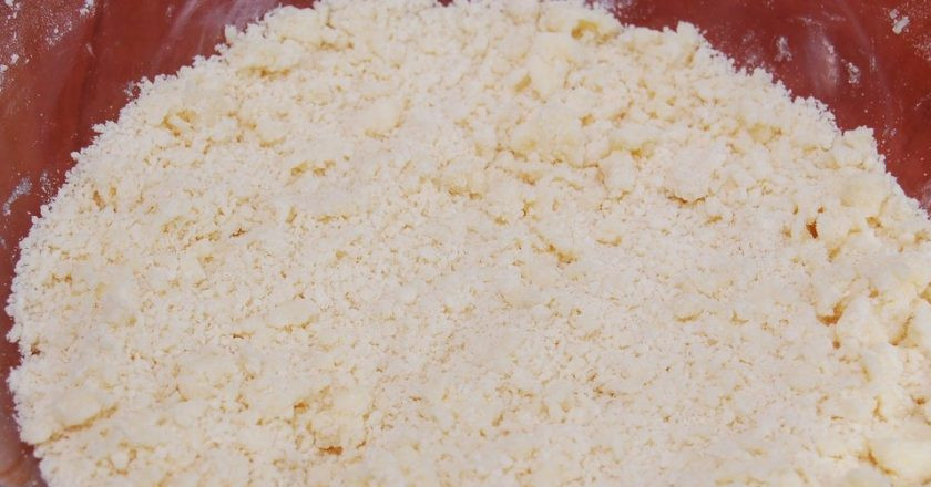 1. Этап. Торт Творожник: В емкость к маслу с сахаром просейте муку с разрыхлителем. Вымесите тесто руками. Должно получиться песочное тесто.