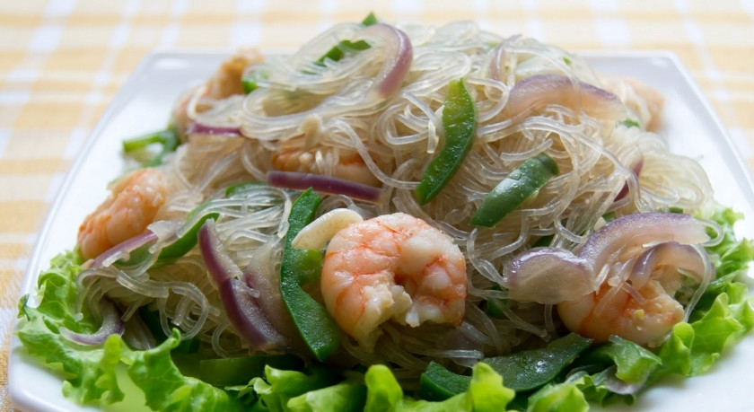 1. Этап. Стеклянная вермишель с креветками и соусом: Выложите на блюдо листья салата, а на них — вермишель с креветками и овощами. Соус, который остался в сковородке, подайте отдельно (или полейте им блюдо).