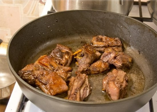 1. Этап. Оленина в горшочке: В сковороду влейте растительное масло, обжарьте на нем морковь, лук и сладкий перец. Достаньте из маринада бараньи ребра и обжарьте их в отдельной сковороде или казанке до золотистого цвета.