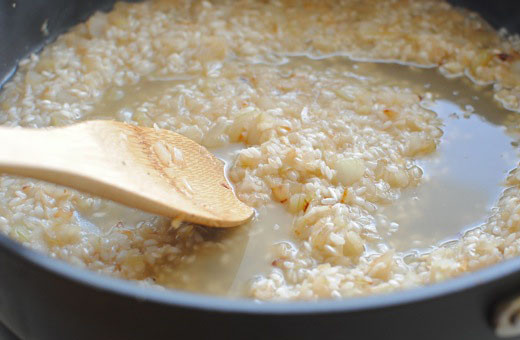 1. Этап. Ризотто с кабачками и помидорами: По истечении времени вливаем на сковороду вино, рис довольно быстро впитает его. Далее вам следует добавить 0,5-1 стакан бульона и продолжать готовить рис на медленном огне, подливая по мере впитывания жидкости по пол стаканчика бульона.