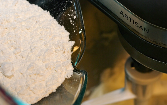 1. Этап. Ореховые пирожные на десерт: Добавьте ванильный сахар и муку, смешанную с разрыхлителем.