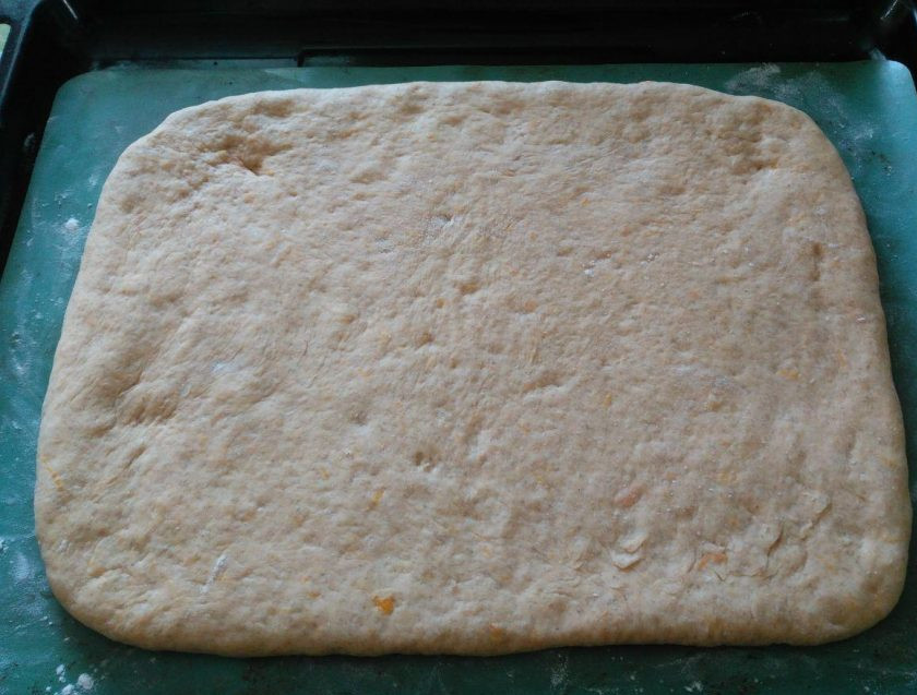 1. Этап. Тыквенный пирог с ягодами и штрейзелем: Обомните готовое тесто руками и разделите на 2 части (для формирования двух пирогов размером 15 на 20 см), раскатайте толщиной 1,5-2 см. Поместите раскатанный пласт на смазанный или застеленный ковриком противень.