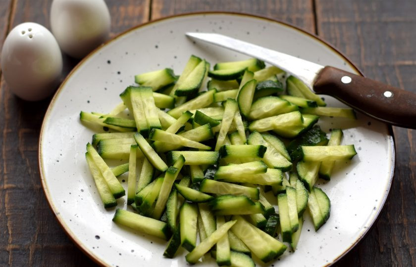 1. Этап. Салат с курицей, пекинской капустой и черносливом: Свежий огурец нашинкуйте тонкой соломкой.