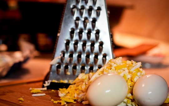 1. Этап. Салат Оливье со свежим огурцом: Яйца отварить вкрутую, остудить, очистить от скорлупы. Измельчить ножом или натереть на крупной терке.