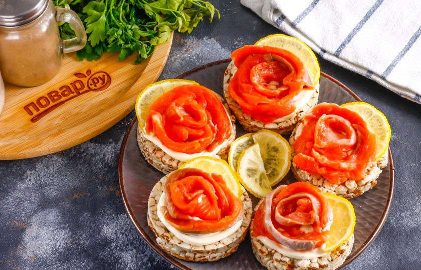 1. Этап. Бутерброды к шампанскому: Нарежьте лимон ломтиками и выложите на бутерброды.