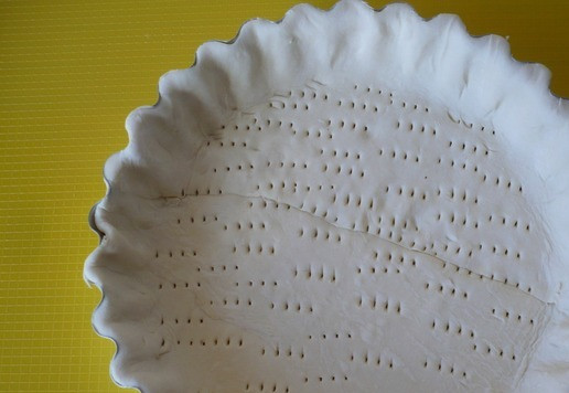 1. Этап. Слоеный пирог с беконом и ветчиной: Выложите слоеное тесто в форму для выпечки пирога (d-21 см), наколите его вилкой, застелите тесто пергаментом и посыпьте дно сухой фасолью (горохом или рисом) и выпекайте в течение 10 минут при температуре 180 градусов.