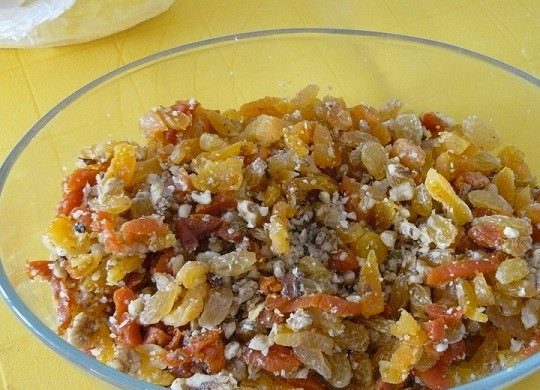 1. Этап. Рулет из сухофруктов и орехов: 3. Измельчите острым ножом орешки и курагу, чтобы начинка была более нежной. На данном этапе можно добавить в этот простой рецепт рулета из сухофруктов и орехов ложку меда, щепотку корицы.