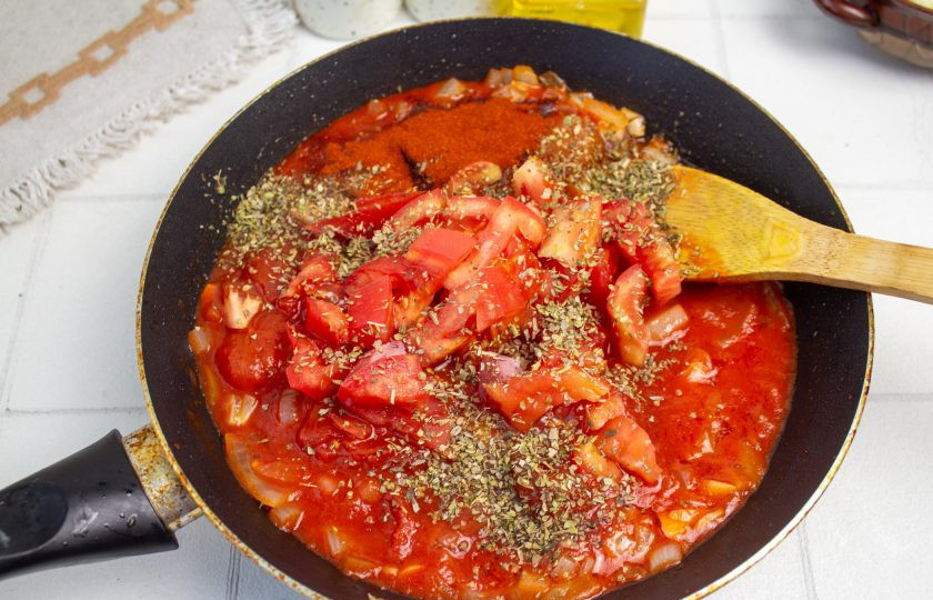 1. Этап. Лазанья с помидорами и сыром: Свежие помидоры нарежьте небольшим кубиком и добавьте в сковороду к томатному соусу. Добавьте соль, сахар, черный молотый перец и сушеный базилик. Тушите соус минут 10.