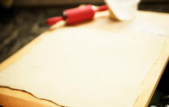 1. Этап. Пряные сырные палочки: 1. Разогреть духовку до 200 градусов. Выстелить противень силиконовым ковриком или пергаментной бумагой. На слегка посыпанной мукой поверхности раскатать лист слоеного теста, чтобы он стал достаточно тонким. Старайтесь сохранять квадратную форму, насколько это возможно. Периодически проверяйте, не прилипает ли тесто к поверхности, и добавьте дополнительно муку в случае необходимости.