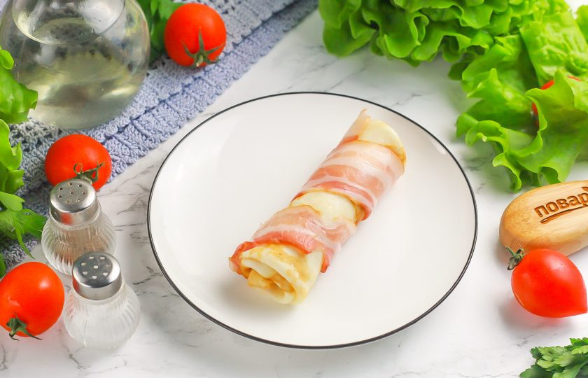 1. Этап. Блинчики с сыром и беконом: Обверните блинный рулетик полосой бекона. Можно использовать соленый или подкопченный варианты.