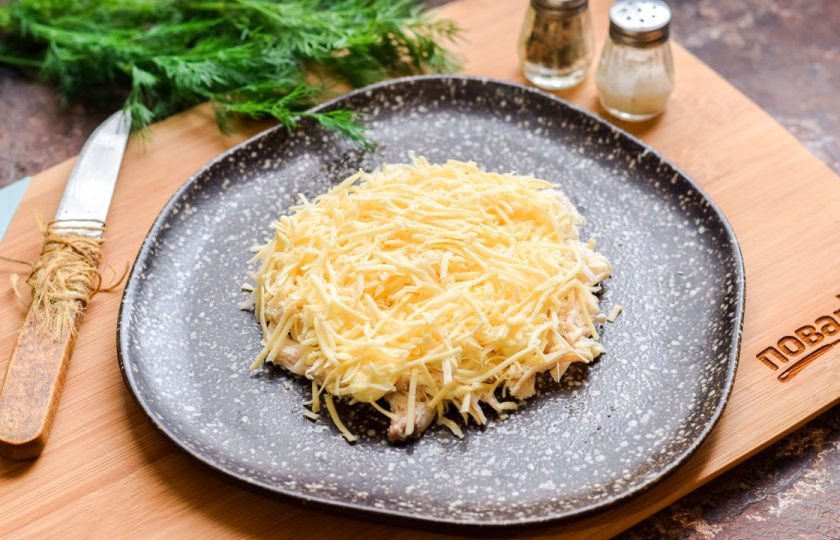 1. Этап. Слоеный салат с курицей Бычок: Твердый сыр натрите на мелкой терке и выложите поверх курицы.
