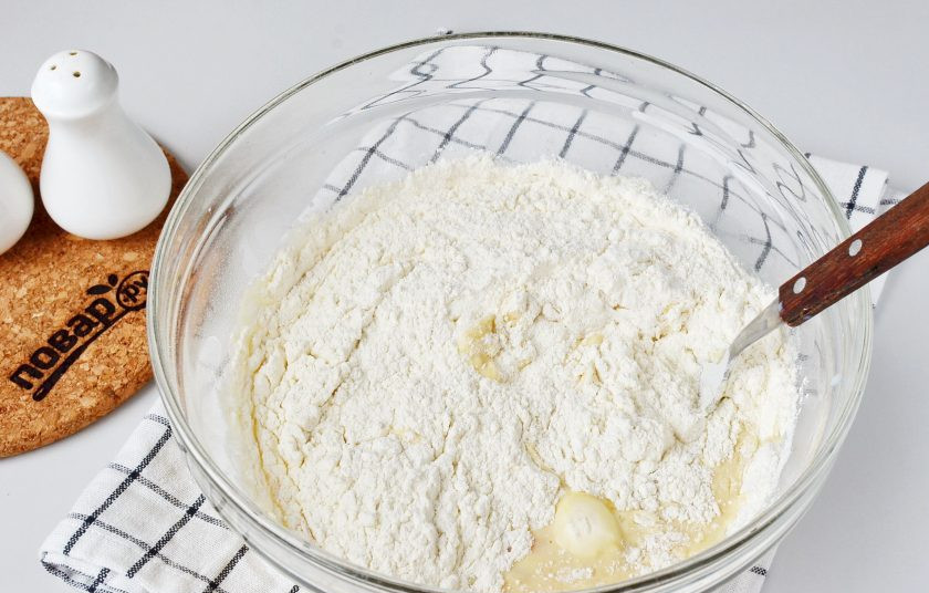 1. Этап. Начинка для расстегаев: Добавьте просеянную муку. Начните замешивать тесто ложкой.