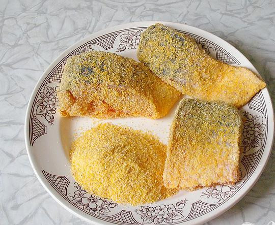 1. Этап. Жареная кефаль: 3. Небольшое количество просеянной на сито кукурузной муки насыпаем на тарелку или на лист бумаги. Для этого хорошо подойдет мука среднего помола, если чуть красноватая, то это еще лучше. Кусочки рыбы запанируем в муке.