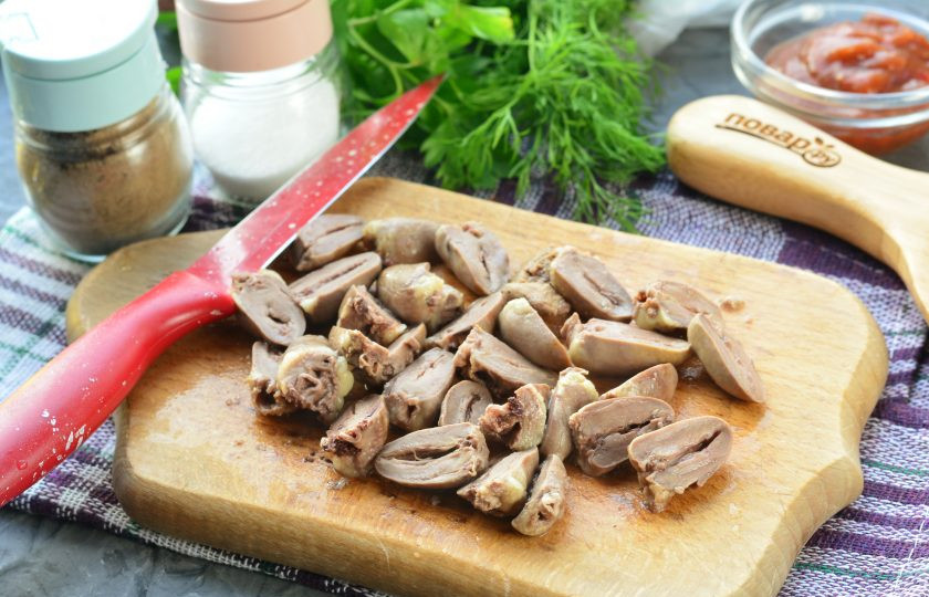 1. Этап. Куриные сердечки по-грузински: Отварные сердечки нарежьте половинками, срезая жир.