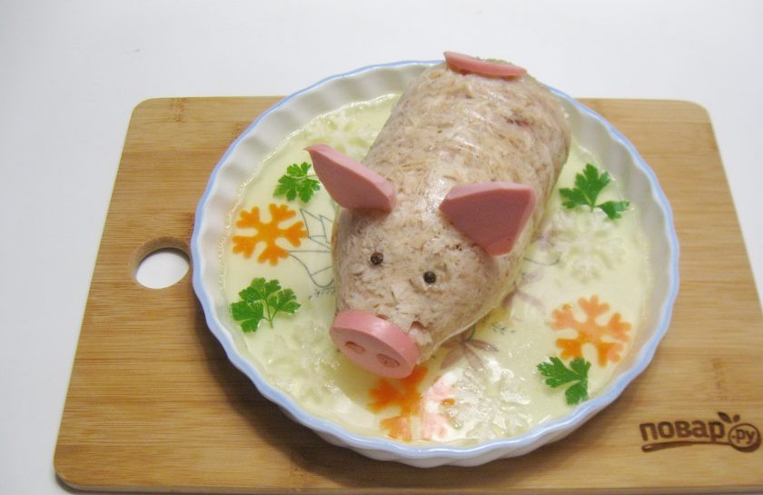 1. Этап. Холодец Новогодний поросенок: Когда бульон застынет, украсьте холодец по вкусу. У меня это снежинки из белой редьки, моркови и петрушка. Из колбасы сделайте ушки, пятачок и хвостик. Из перца глазки.