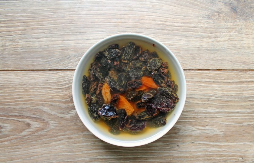 1. Этап. Еврейский цимес: Выложите в миску курагу, чернослив и изюм. Залейте сухофрукты кипятком и оставьте на 15 минут. Слейте воду и промойте их теплой водой, дайте ей стечь.