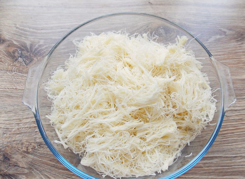 1. Этап. Кюнефе: Тесто разделите на отдельные волокна и порвите или порежьте на кусочки.