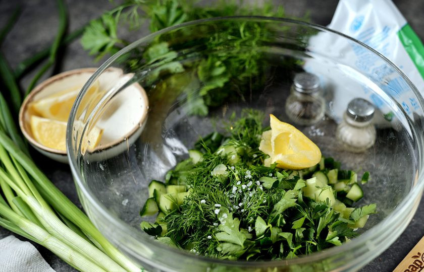 1. Этап. Летний суп на кефире: Порубите укроп и петрушку, добавьте в миску к овощам, всыпьте соль и перец по вкусу, выдавите лимонный сок.