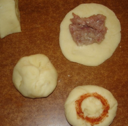 1. Этап. Пироги на пару: Сделайте из теста жгут и разделите его на кусочки, размером 5 на 5 см. Обмакиваем их в муку и раскатываем в небольшие лепешки. В центр каждой лепешки кладем фарш и собираем тесто 