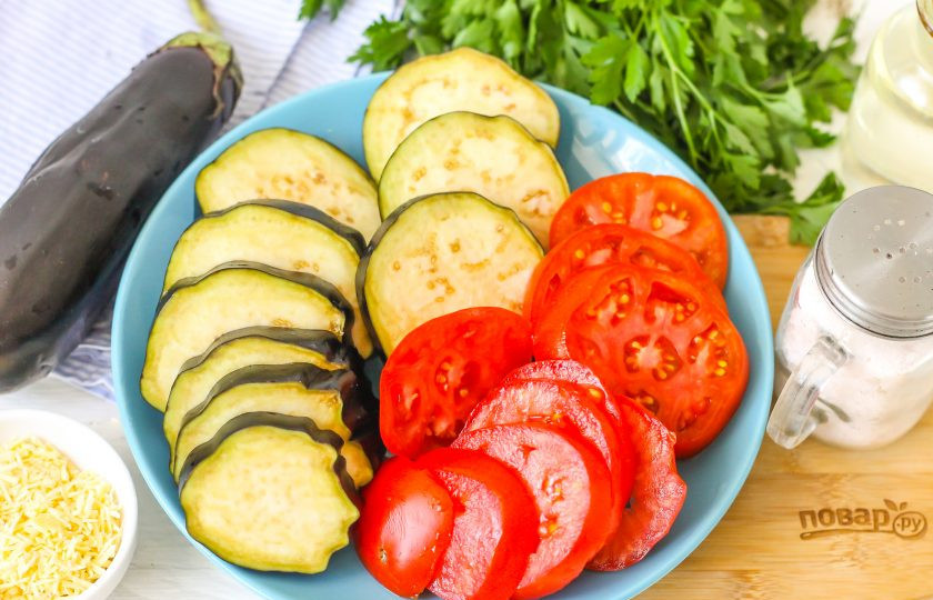 1. Этап. Медальоны из баклажанов: Промойте овощи в воде, срежьте у баклажанов хвостики, а из помидоров вырежьте зеленые сердцевинки. Нарежьте все овощи кружочками не толще 1-1,5 см.