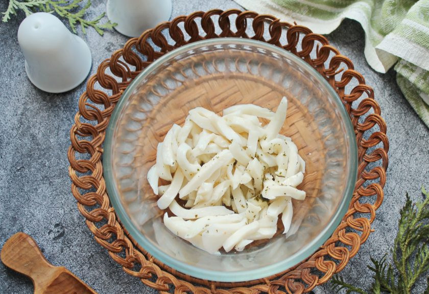 1. Этап. Салат из кальмаров с чесноком: С кальмаров слейте масло и выложите их в салатник.