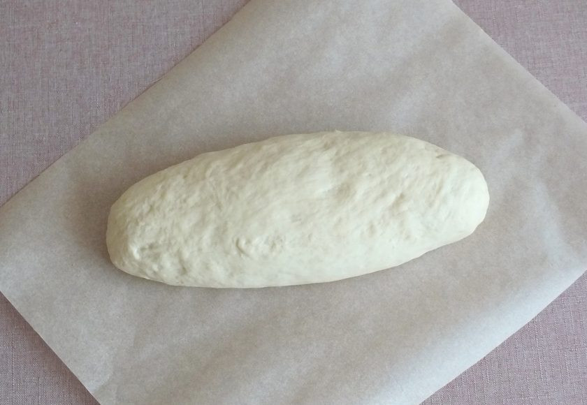 1. Этап. Батон Подмосковный: Сформуйте батон, переложите на бумагу для выпечки. Накройте полотенцем и оставьте на 1 час для подъема.