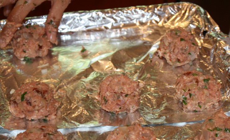 1. Этап. Паста с фрикадельками в томатном соусе: Из приготовленного фарша формируем небольшие фрикадельки и выкладываем их на противень, застланный фольгой и смазанный небольшим количеством масла.