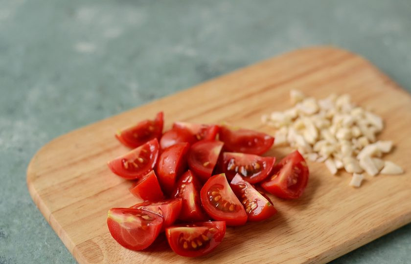 1. Этап. Салат с манго и ананасом: Помидоры черри нарежьте на четвертинки, орехи крупно порубите ножом.