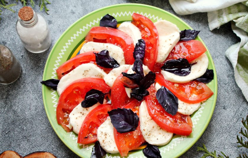 1. Этап. Салат Капри: Разложите поверх моцареллы и помидоров листики базилика и полейте салат оливковым маслом.