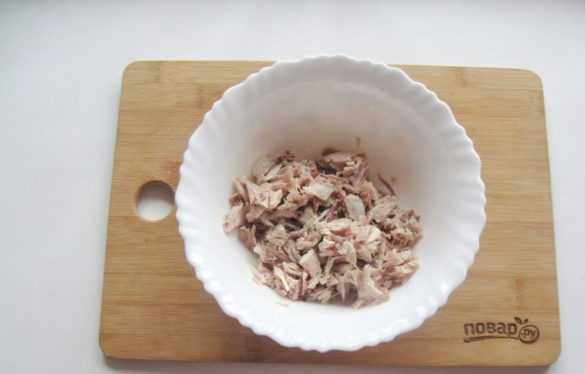 1. Этап. Салат Снежинка с курицей: Отварное куриное мясо мелко нарежьте и выложите в миску.