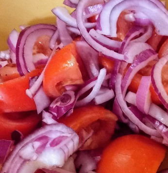 1. Этап. Салат из тунца, фасоли и помидоров: Нарезать помидоры крупными кубиками, посолить, поперчить и выложить на блюдо. Они сформируют основу салата. На помидоры выложить красный лук. Полить 1 столовой ложкой оливкового масла.