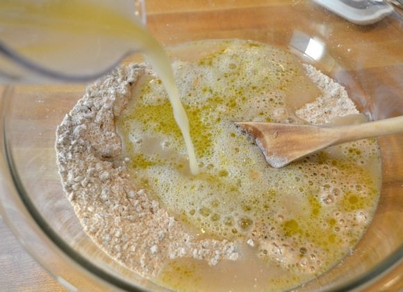 1. Этап. Хлеб с семечками: 4. Добавьте к муке оливковое масло, влейте дрожжевую смесь, перемешайте и добавьте оставшиеся 0,5 стакана цельнозерновой муки.