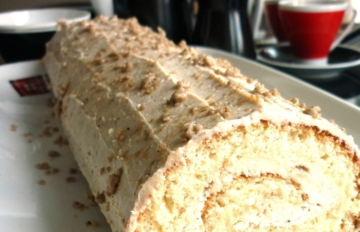 1. Этап. Выпечка с халвой: На остывший бисквит намажьте начинку. Сверните его плотно, прикрыв мокрым полотенцем на 5 минут. Затем сверху покройте рулет кремом и орехами. Приятного чаепития!