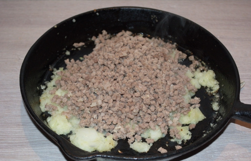 1. Этап. Блинный пирог с фаршем: Репчатый лук нарезать кубиком. На растительном масле обжарить лук. Добавить его в фарш. Жарить все вместе. При обжарке добавьте немного воды и тушите до мягкости. По вкусу добавьте соль и специи.