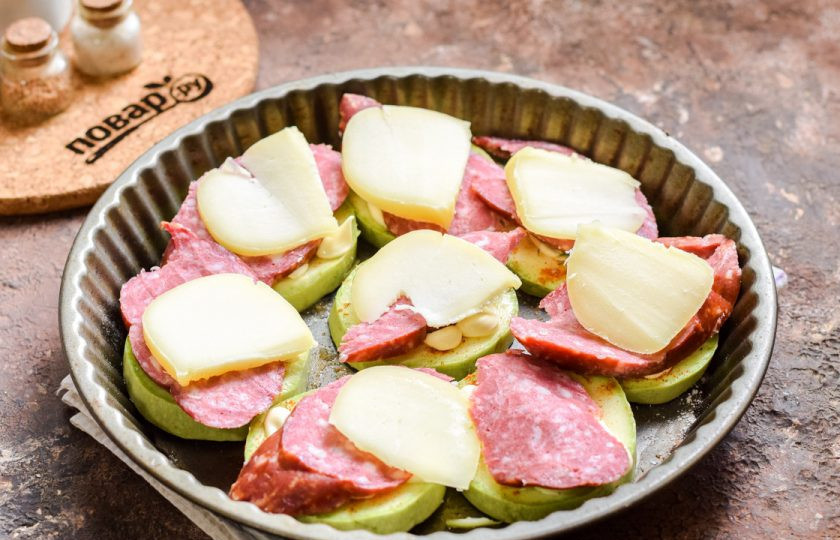 1. Этап. Кабачки под шубой в духовке: Поверх выложите пластины нарезанного сыра. Запекайте в духовке при температуре 180 градусов в течение 25 минут.